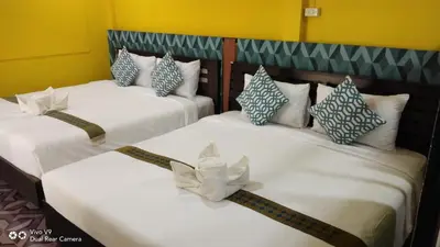 two beds in a room with white and blue pillows at Baan Asree homestayบ้านอัสรี in Ao Nang Beach