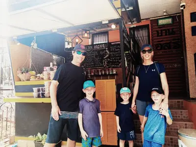 a family posing for a picture in front of a restaurant at Baan Asree homestayบ้านอัสรี in Ao Nang Beach