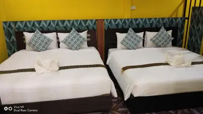 two beds in a room with white and blue pillows at Baan Asree homestayบ้านอัสรี in Ao Nang Beach