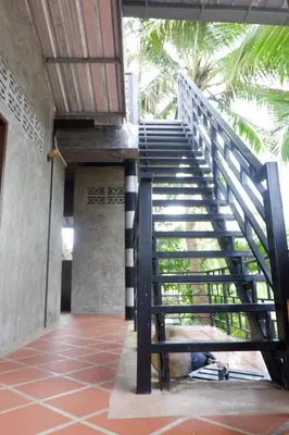 a staircase leading up to a building with palm trees at Bussarin Mansion Koh Yao Yai in Ko Yao Yai