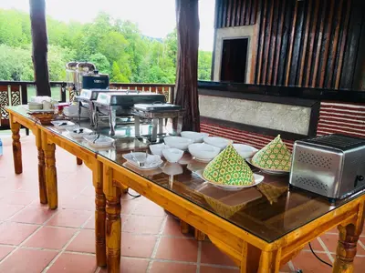 a wooden table with bowls and dishes on it at Bussarin Mansion Koh Yao Yai in Ko Yao Yai