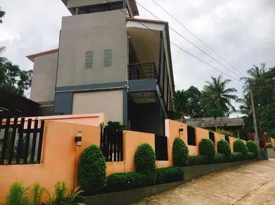 a house with a fence and bushes in front of it at Bussarin Mansion Koh Yao Yai in Ko Yao Yai