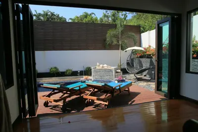 a patio with two picnic tables and a pool at Naiharn Beach Villa in Nai Harn Beach