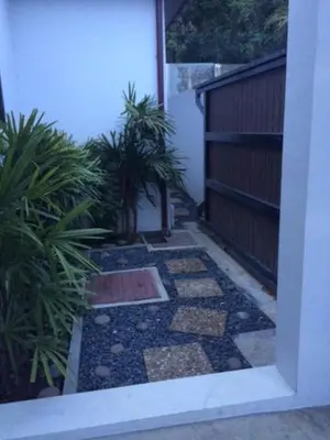 an outside walk way with plants and a building at Naiharn Beach Villa in Nai Harn Beach