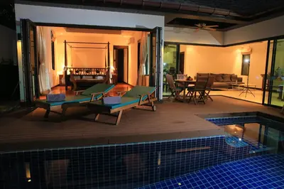 a house with a swimming pool and a living room at Naiharn Beach Villa in Nai Harn Beach