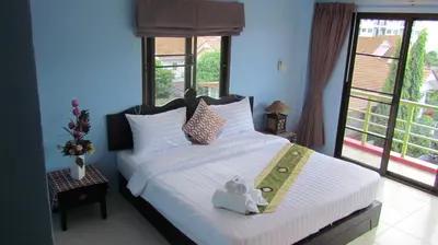 a bedroom with a large bed with white sheets at La Piccola Patong in Patong Beach