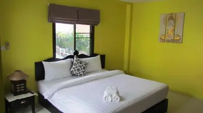 a bedroom with a bed with white sheets and a window at La Piccola Patong in Patong Beach