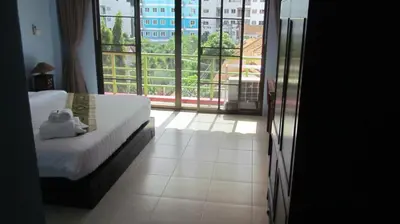 a bedroom with a bed and a large window at La Piccola Patong in Patong Beach