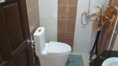 a bathroom with a white toilet and a sink at La Piccola Patong in Patong Beach