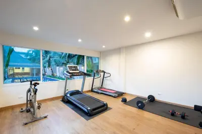 a room with a gym with a treadmill and a phone at Impress Resort in Thalang