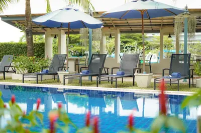 a pool with chairs and umbrellas at Impress Resort in Thalang