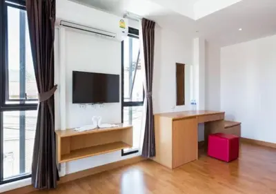 a living room with a television and a large window at Buk Inn Hotel SHA Plus in Kamala Beach