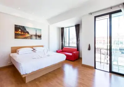a bedroom with a bed and a red chair at Buk Inn Hotel SHA Plus in Kamala Beach