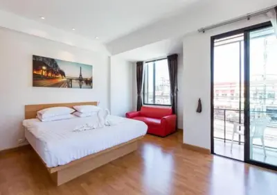 a bedroom with a bed and a red chair at Buk Inn Hotel SHA Plus in Kamala Beach