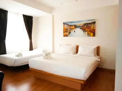 a hotel room with two beds and a painting on the wall at Buk Inn Hotel SHA Plus in Kamala Beach