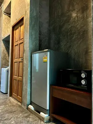 a refrigerator next to a microwave next to a door at Phuchada Residence in Nai Yang Beach