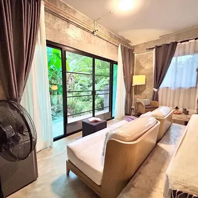 a bedroom with two beds and a large window at Phuchada Residence in Nai Yang Beach