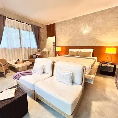 a bedroom with a large bed and a couch at Phuchada Residence in Nai Yang Beach