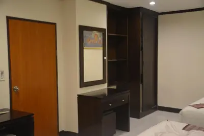 a bedroom with a bed and a dresser and a mirror at Patong Moon Inn Residence in Patong Beach