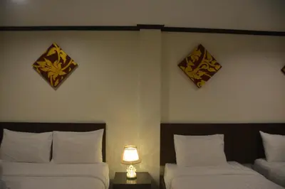 a bedroom with two beds and a lamp on a table at Patong Moon Inn Residence in Patong Beach