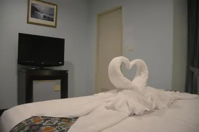 a couple of swans sitting on top of a bed at Patong Moon Inn Residence in Patong Beach