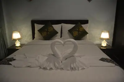 two white swans making a heart on a bed at Patong Moon Inn Residence in Patong Beach