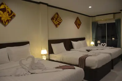 a hotel room with three beds with swans on them at Patong Moon Inn Residence in Patong Beach