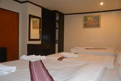 two beds in a hotel room with towels on them at Patong Moon Inn Residence in Patong Beach