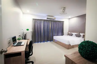 a bedroom with a bed and a desk with a computer at Vipa House Phuket - SHA Extra Plus in Chalong