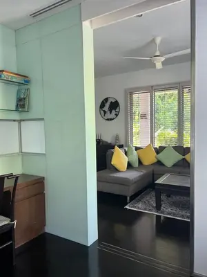 a living room with a gray couch and yellow pillows at Kata Gardens Apartments in Kata Beach