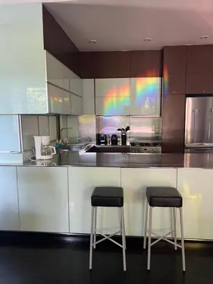a kitchen with two stools sitting at a counter at Kata Gardens Apartments in Kata Beach