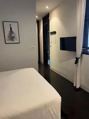 a bedroom with a white bed and a flat screen tv at Kata Gardens Apartments in Kata Beach