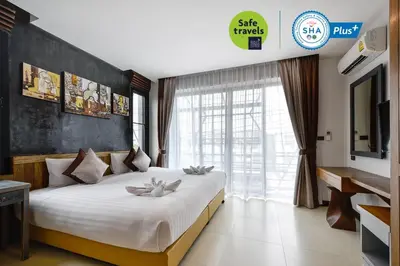 a bedroom with a large bed with a large window at Casa Bella Phuket in Chalong