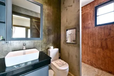 a bathroom with a sink and a toilet and a mirror at Casa Bella Phuket in Chalong
