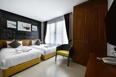 a hotel room with two beds and a desk at Casa Bella Phuket in Chalong