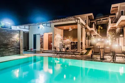 a swimming pool in a house at night at Thuan Resort in Rawai Beach