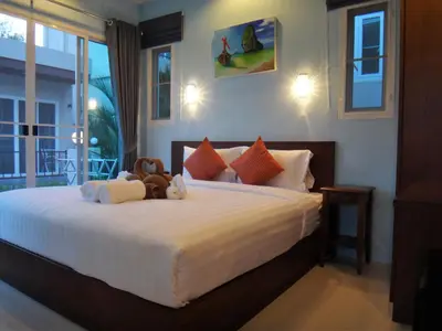 a bedroom with a bed with stuffed animals on it at Thuan Resort in Rawai Beach