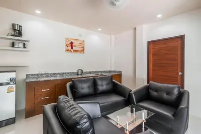 a living room with two leather chairs and a counter at Thuan Resort in Rawai Beach
