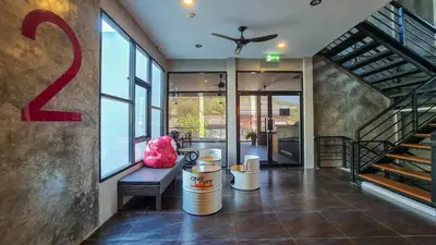a lobby of a building with a staircase and a room at OneLoft Hotel in Karon Beach