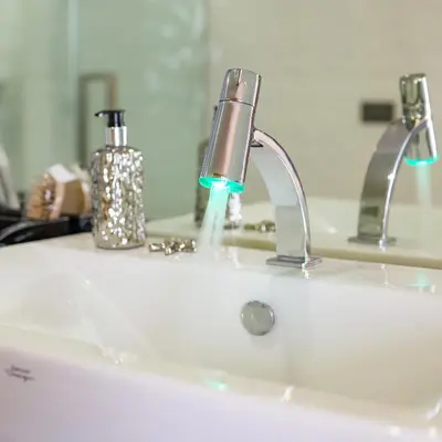 a bathroom sink with a faucet with water coming out at OneLoft Hotel in Karon Beach