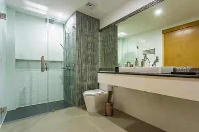 a bathroom with a shower and a toilet and a sink at OneLoft Hotel in Karon Beach