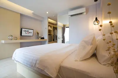 a bedroom with a large white bed with white pillows at OneLoft Hotel in Karon Beach