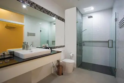 a bathroom with a sink and a glass shower at OneLoft Hotel in Karon Beach