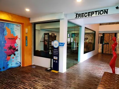 a store entrance with a red statue in front of it at OneLoft Hotel in Karon Beach