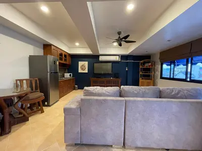 a living room with a couch and a kitchen at Summer Breeze Hotel in Patong Beach