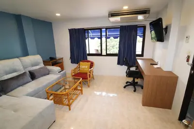 a living room with a couch and a desk at Summer Breeze Hotel in Patong Beach