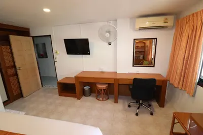 a room with a desk and a television on the wall at Summer Breeze Hotel in Patong Beach