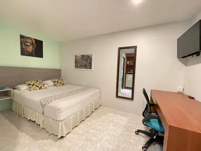a bedroom with a bed and a desk and a television at Summer Breeze Hotel in Patong Beach