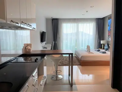a room with a desk and a bedroom with a bed at Emerald Terrace Apartments by Lofty in Patong Beach