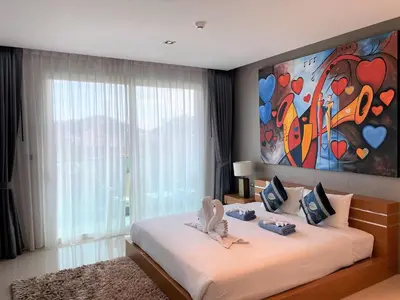 a bedroom with a bed with a painting on the wall at Emerald Terrace Apartments by Lofty in Patong Beach